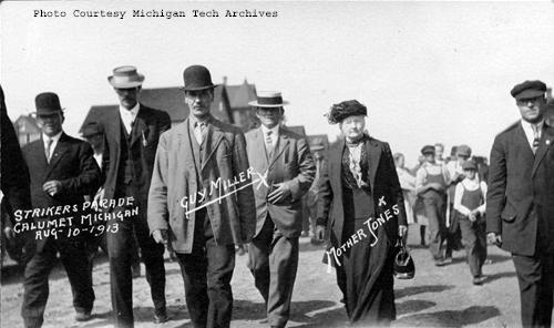 Mother Jones and Guy Miller (WFM) lead a labor parade in Calumet.  They are joined by strikers and young boys to show support for all on strike. (Photo courtesy of the MTU Archives, Keweenaw Digital Archive, available here)